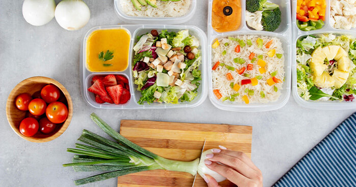 Woman cutting vegetables for food prepping.